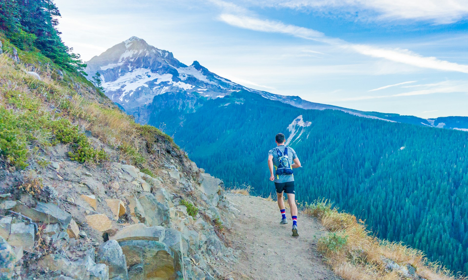 Trail runner descending a mountain path.