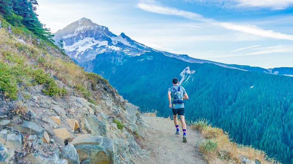 Trail runner descending a mountain path.